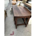 AN OAK DROP LEAF DINING TABLE