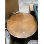 A CIRCULAR WOODEN TOP COFFEE TABLE