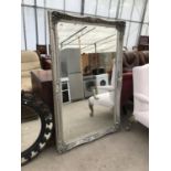 A LARGE RECTANGULAR MIRROR WITH A SILVER COLOURED FRAME
