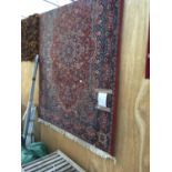 A LARGE RED AND BLUE PATTERNED RUG 244CM X 168CM
