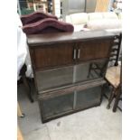 AN MINTY OAK BOOKCASE WITH TWO DOORS AND TWO SETS OF GLASS SLIDING DOORS