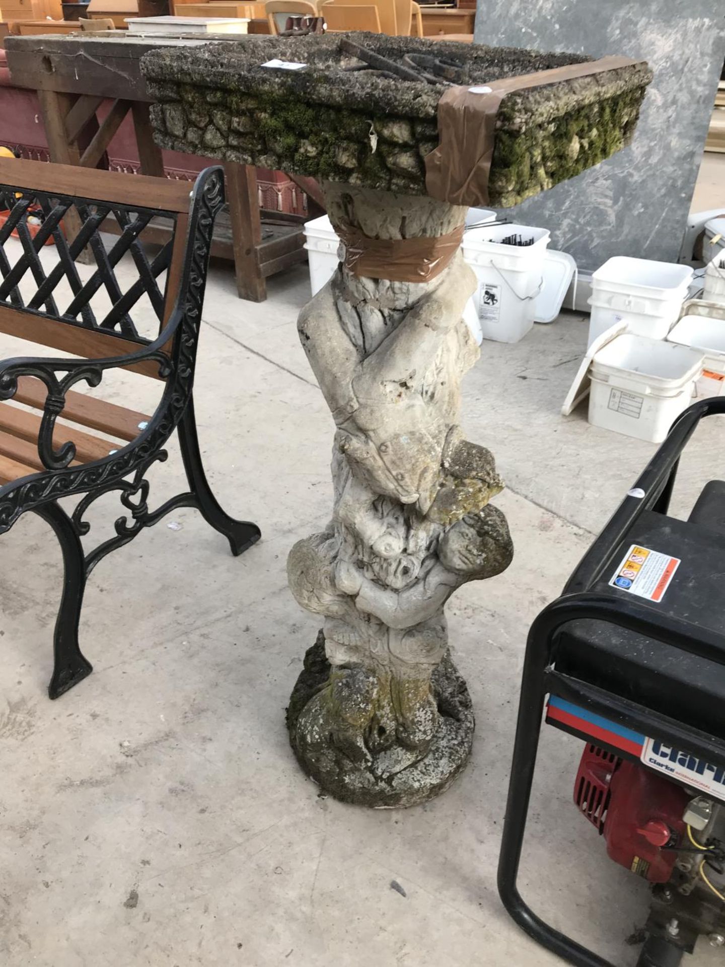 A CONCRETE BIRDBATH WITH GARGOYLE DECORATED COLUMN SUPPORT