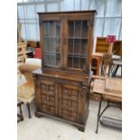 AN OAK CABINET WITH TWO LOWER DOORS AND TWO UPPER LEAD GLAZED DOORS