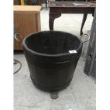 A WOODEN HALF BARREL STYLE PLANTER WITH BRASS HANDLES AND FEET