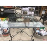 A LARGE SQUARE GLASS TOPPED TABLE ON METAL SUPPORTS WITH A CREAM FOLDING BISTRO STYLE CHAIR