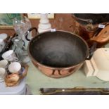 A LARGE TWIN HANDLED COPPER BOWL