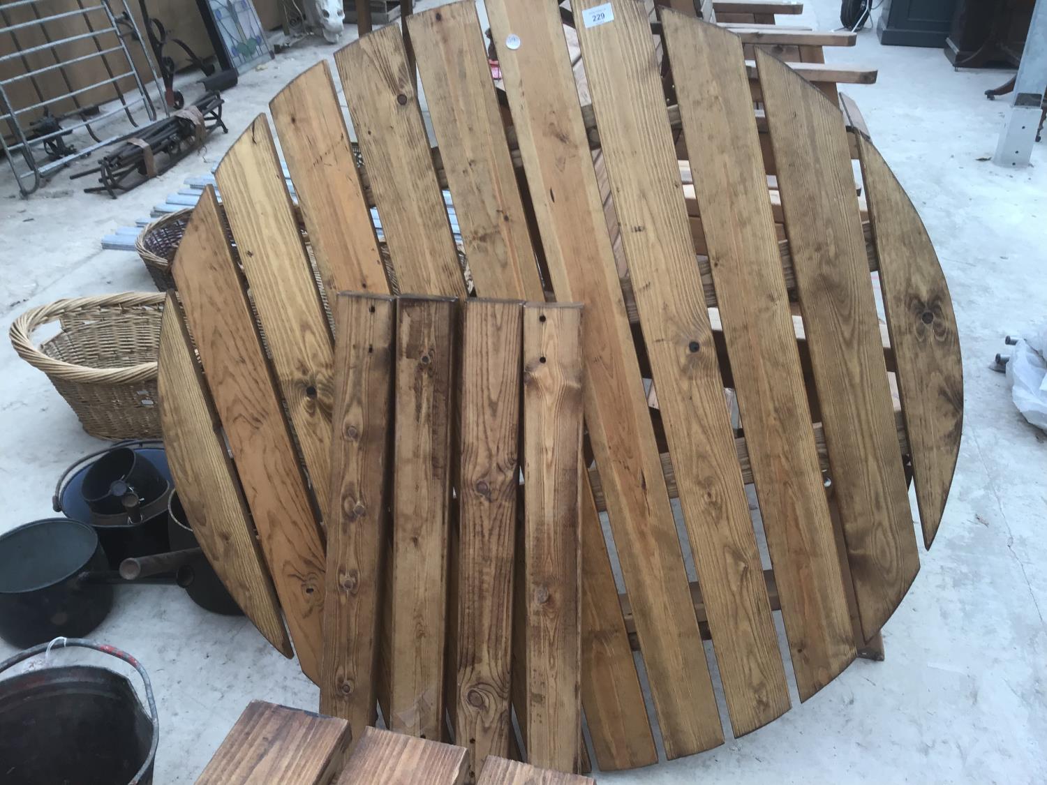 A ROUND WOODEN GARDEN TABLE WITH LEGS (NO BOLTS)