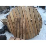 A ROUND WOODEN GARDEN TABLE WITH LEGS (NO BOLTS)