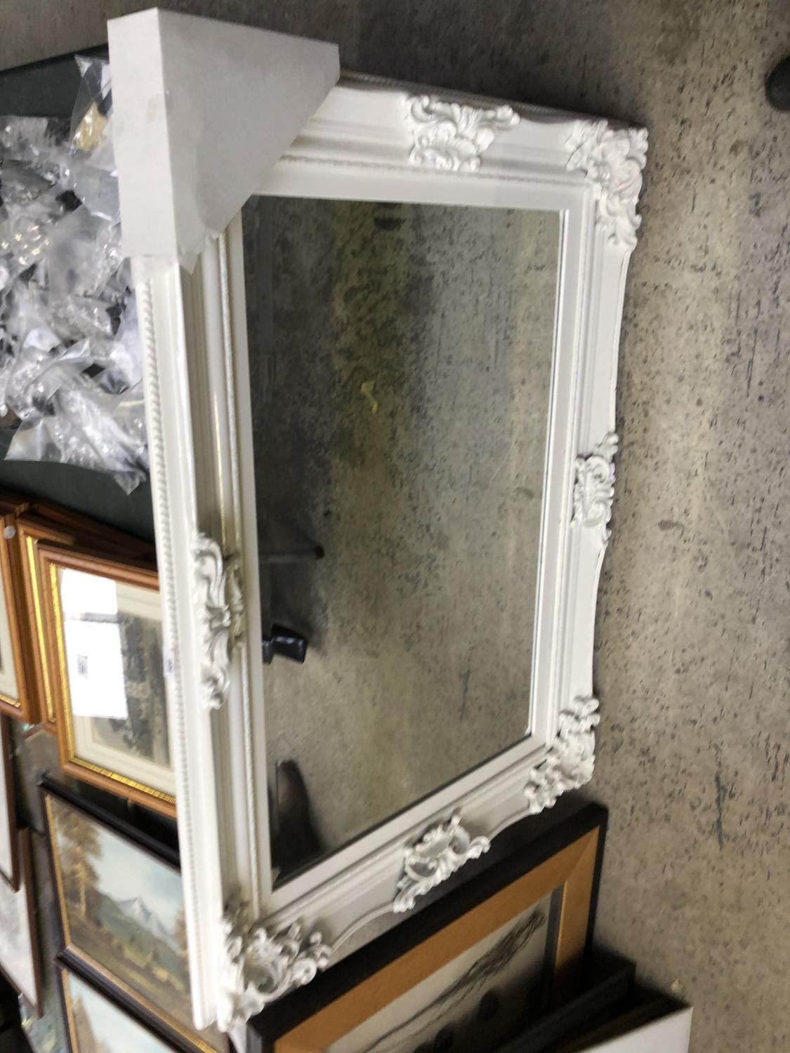A LARGE WHITE ORNATE MIRROR
