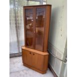 A TURNIDGE TEAK CORNER CABINET WITH TWO LOWER DOORS AND TWO UPPER GLAZED DOORS