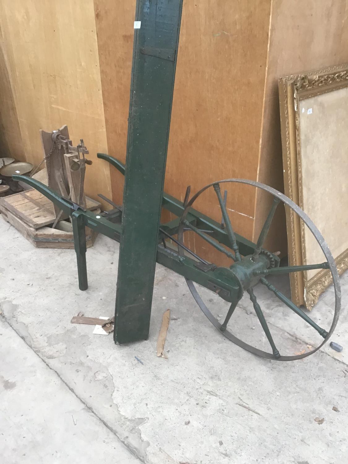 A GREEN PAINTED VINTAGE SEED DRILL IN GOOD CONDITION