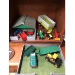 A LARGE MIXED LOT OF MODEL TRACTORS AND OTHER VEHICLES IN WOODEN YARD AND GARAGE