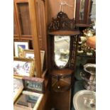 A MAHOGANY HANGING SHELF UNIT WITH MIRRORED PANEL