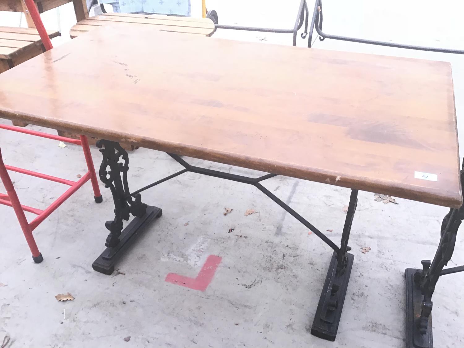 A RECTANGULAR WOODEN TOP TABLE ON A CAST IRON SUPPORT