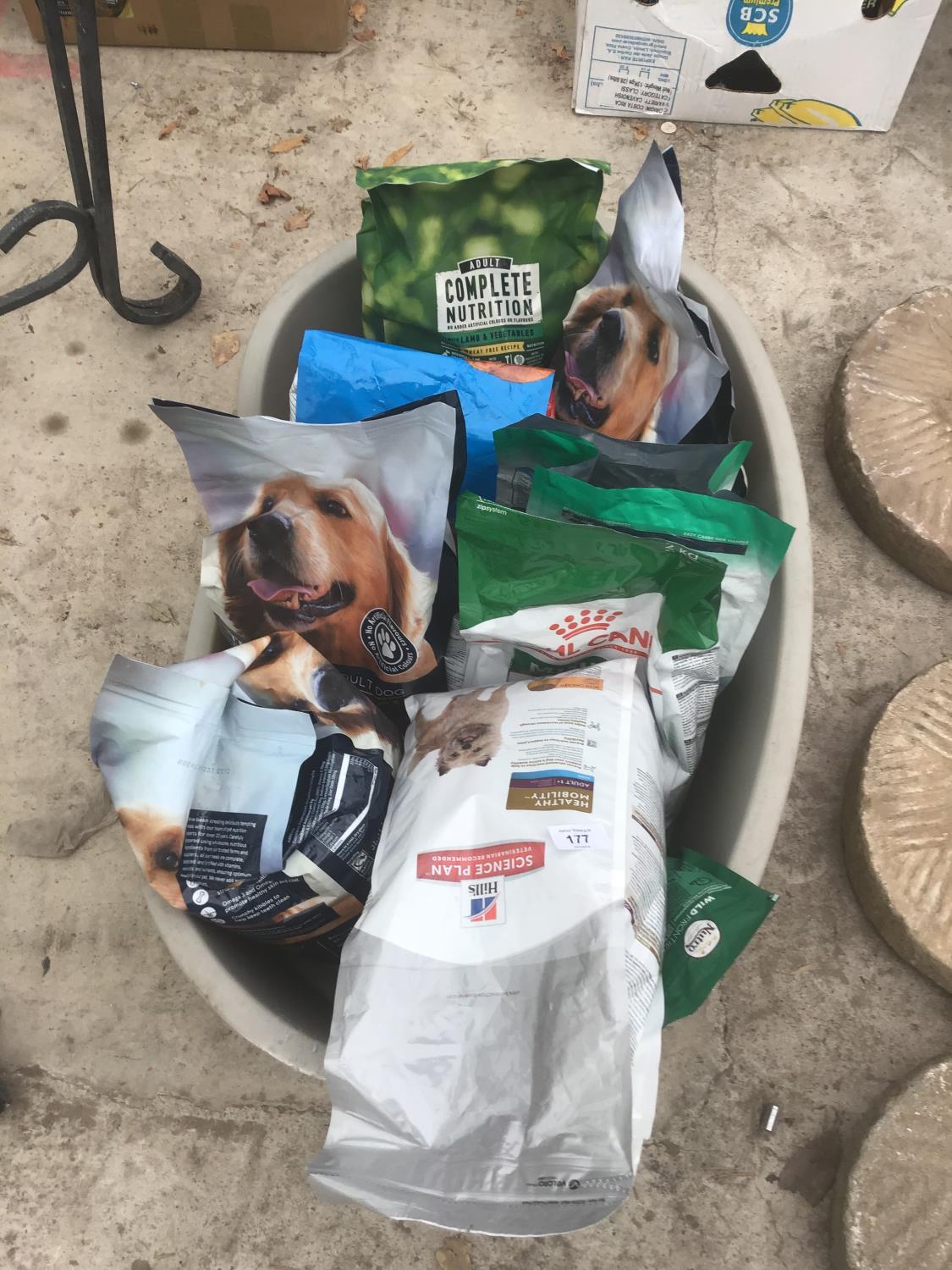 A QUANTITY OF DOG FOOD TO INCLUDE HILLS, ROYAL CANIN ETC IN A LARGE PLASTIC DOG BASKET