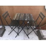 A FOLDING WOODEN BISTRO STYLE TABLE AND TWO CHAIRS