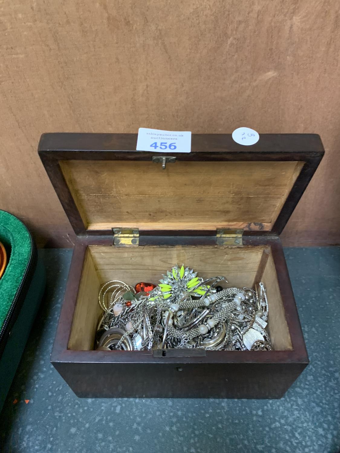 A WOODEN BOX CONTAINING WHITE METAL COSTUME JEWELLERY