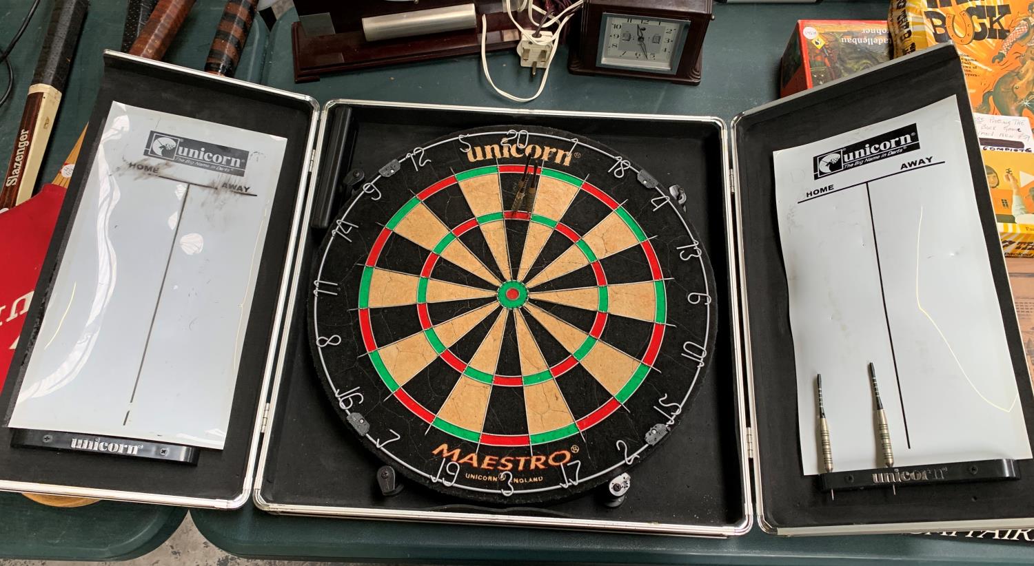 A CASED DARTS BOARD WITH THREE DARTS