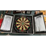 A CASED DARTS BOARD WITH THREE DARTS