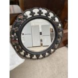 A CIRCULAR MIRROR WITH BLACK AND GILDED FRAME