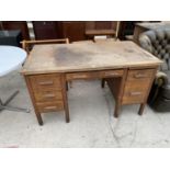 AN OAK TWIN PEDESTAL DESK WITH CENTRE DRAWER AND SIDE DRAWERS