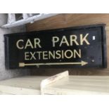 A WOODEN PAINTED 'CAR PARK EXTENSION' SIGN