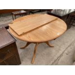 A CIRCULAR EXTENDING OAK DINING TABLE