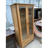 A MODERN OAK CABINET WITH TWO LOWER DRAWERS AND TWO GLAZED DOORS