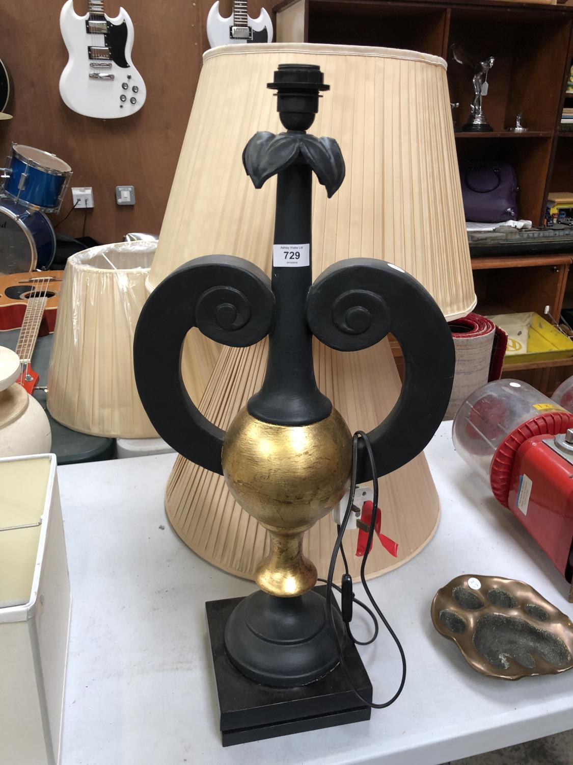 A BLACK AND GOLD LAMP BASE TOGETHER WITH TWO SHADES