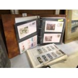 A FOLDER OF ASSORTED POSTCARDS, CIGARETTE CARDS ETC