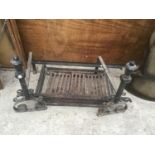 A CAST IRON FIRE GRATE WITH ORNATE STANDS