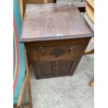 AN OAK BEDSIDE CABINET WITH TWO DOORS AND ONE DRAWER