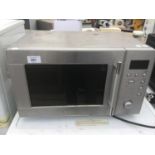 A STAINLESS STEEL MICROWAVE IN WORKING ORDER (SOME INSTRUCTIONS/GUIDE WORN OFF)