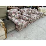 A FLORAL THRE SEATER SOFA WITH TWO MATCHING ARMCHAIRS AND A FOOTSTOOL