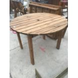 A WOODEN ROUND GARDEN TABLE