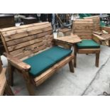 A TWO SEATER WOODEN BENCH AND A ONE SEATER CHAIR AND CONNECTING TABLE WITH GREEN SEAT PADS