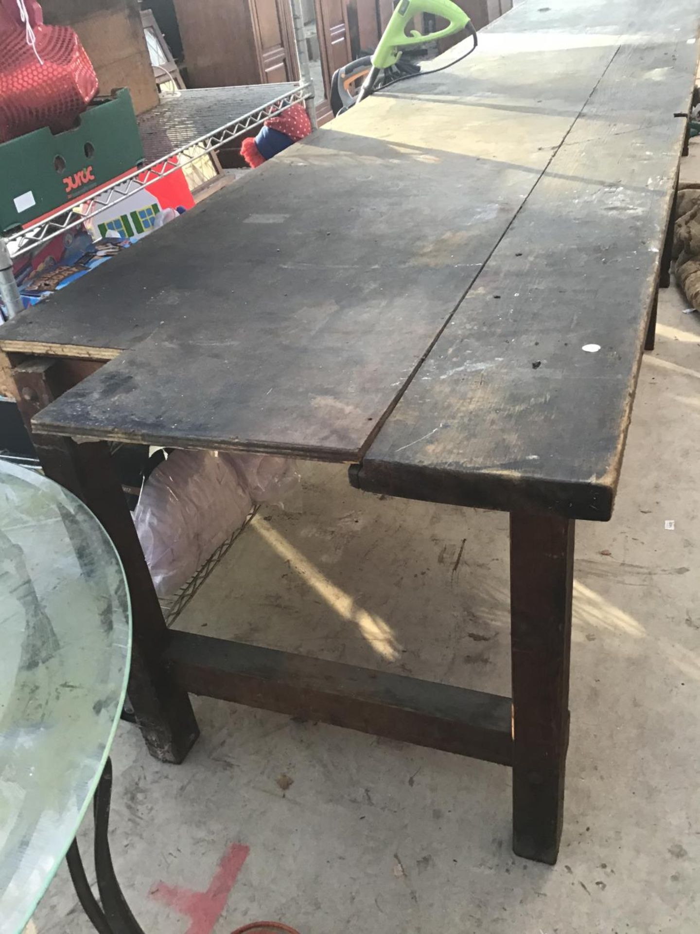 A LARGE WOODEN WORK BENCH/TABLE 244CM X 88CM (CORNER MISSING)