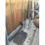 A CHROME CLOTHES RAIL, BRASS FIRE FRONT AND A FIRE GRATE