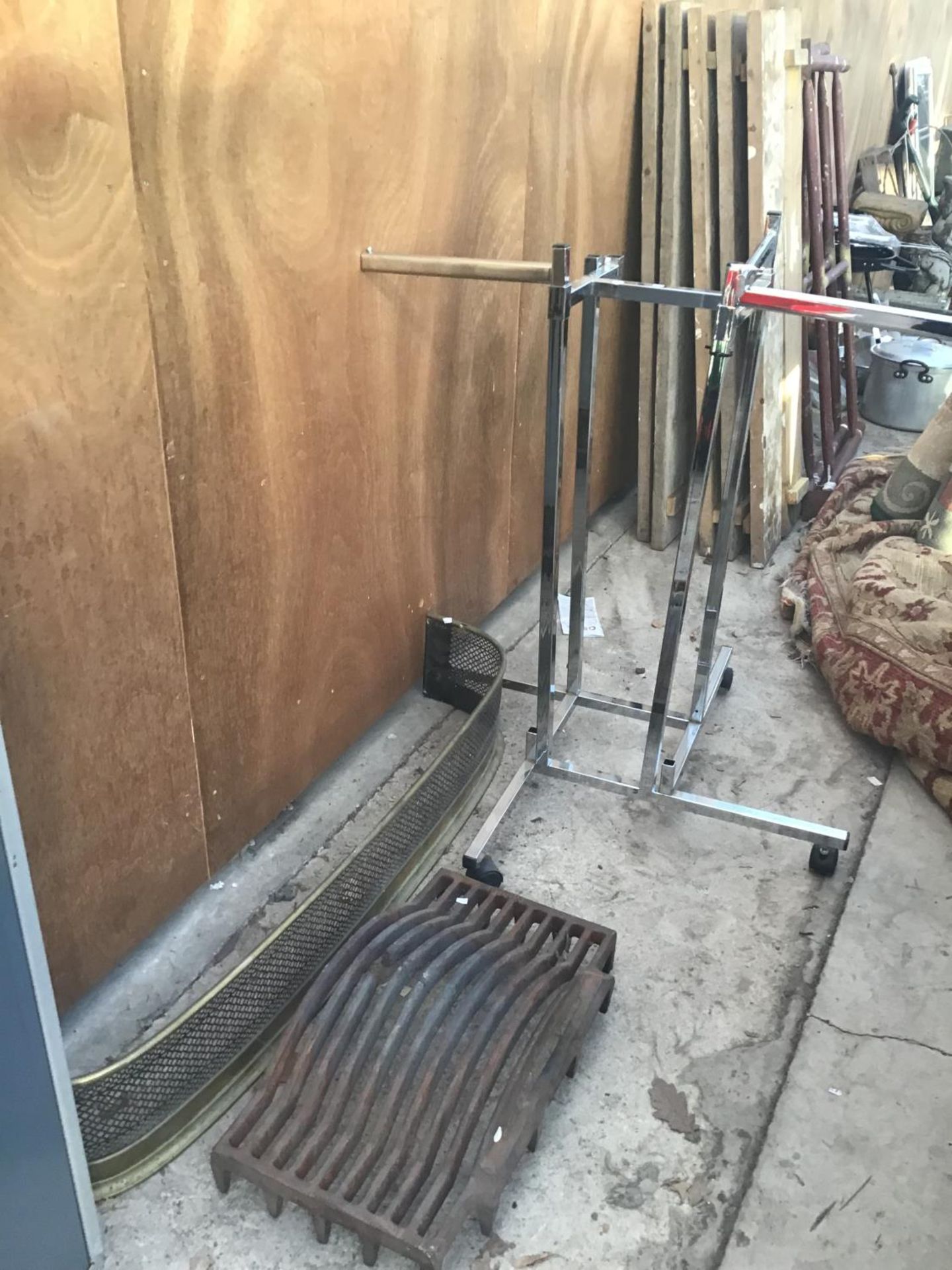 A CHROME CLOTHES RAIL, BRASS FIRE FRONT AND A FIRE GRATE