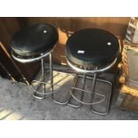 A PAIR OF CHROME FRAMED BAR STOOLS WITH BLACK LEATHERETTE SEATS