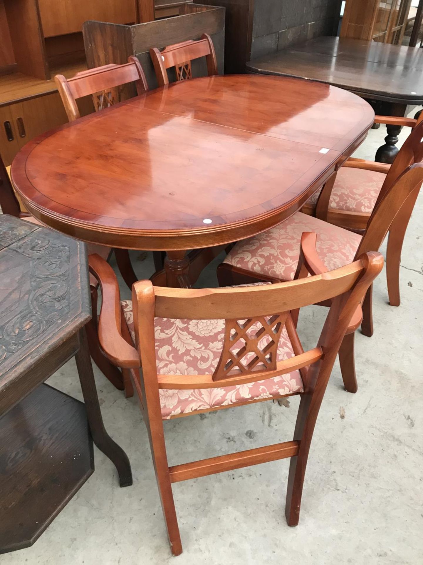 A YEW WOOD EXPENDING DINING TABLE WITH TWO CARVERS AND THREE DINING CHAIRS