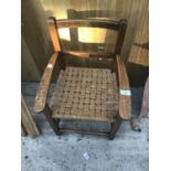 AN OAK FRAMED SMALL CHAIR WITH A WOVEN SEAT