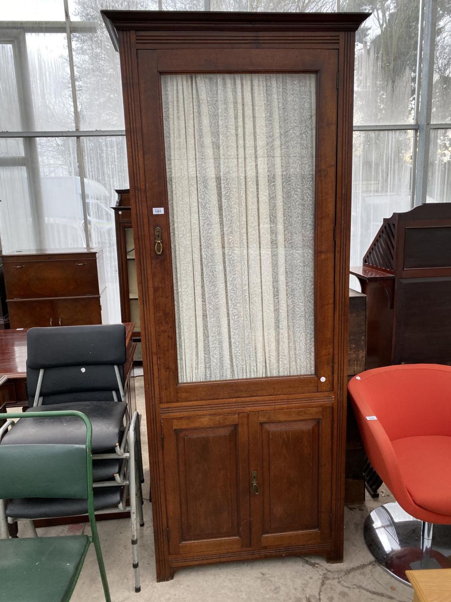 A TALL MAHOGANY CABINET WITH TWO LOWER DOORS AND UPPER GLAZED PANEL DOOR