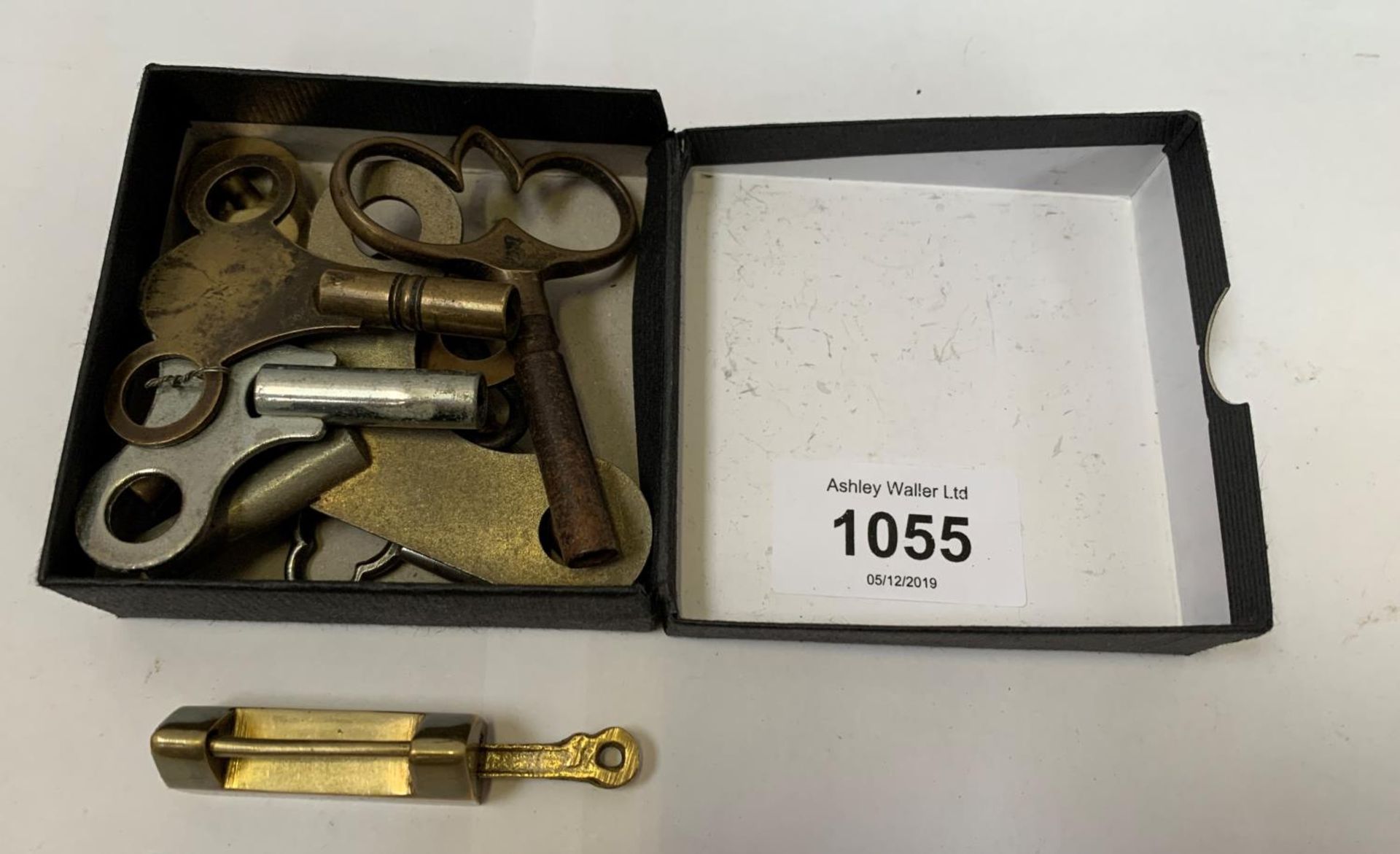 A BRASS LOCK TOGETHER WITH A BOX OF CLOCK KEYS