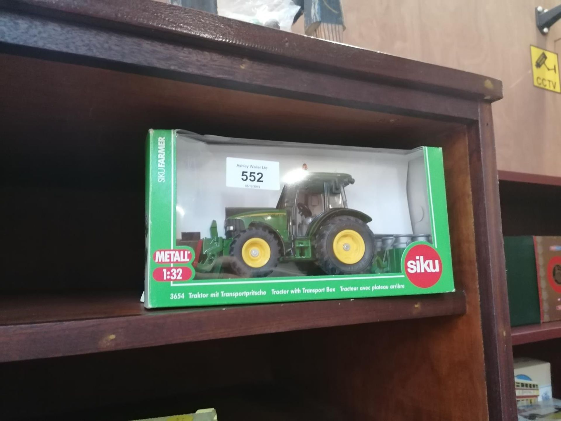 A SIKU 1:32 SCALE TRACTOR MODEL WITH MILK CHURNS