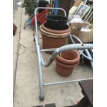 A METAL HAMMOCK FRAME AND VARIOUS LARGE PLANTERS