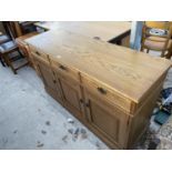AN OAK SIDEBOARD WITH THREE DOORS AND THREE DRAWERS