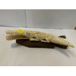 A BONE STYLE CROCODILE ON WOODEN BASE