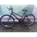 A RALEIGH PURPLE BICYCLE WITH AN 18 GEAR SHIMANO SYSTEM