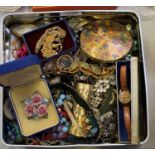 A TIN OF ASSORTED COSTUME JEWELLERY TO INCLUDE BOXED BROOCHES AND WRIST WATCH ETC